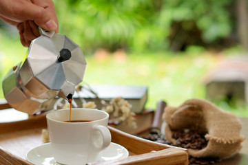 pouring coffee surrounded by coffee beans