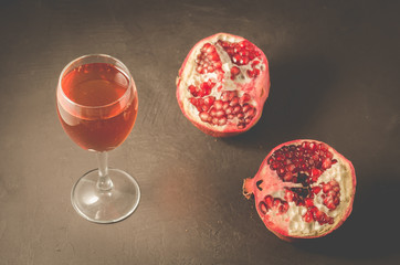 Ripe pomegranate juice on a dark background/Pomegranate fruit and juice in glass on dark background