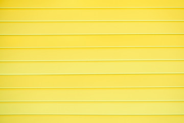 The texture of a plastic wall with horizontal stripes of yellow boards, background