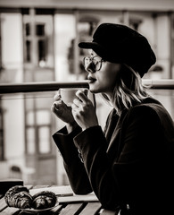 Beautiful young businesswoman have a coffee break while sitting outdoors at home. Concept of work with startup business . Image in black and white color style