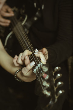 Feeling the music. Male and female hands play the electric guitar. Couple of guitar players. Couple of musicians enjoy playing music. Couple in love play duets. Instrumental music live