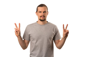 Fototapeta premium Bearded attractive caucasian guy hoding hands with victory sign isolated on white
