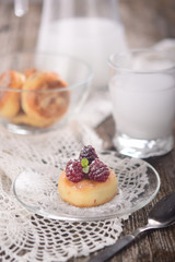 cheesecakes or cottage cheese pancakes, decorated with berries and mint, lie in a plate on a beautifully decorated table on a white lace napkin