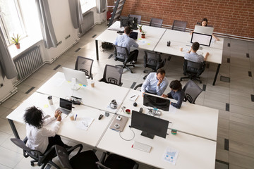 Employees working together in modern open office space, corporate group team employees using...