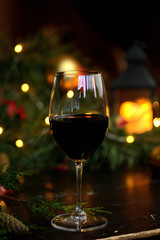 red wine in a glass on the background of garlands, Christmas trees and decorations. Christmas