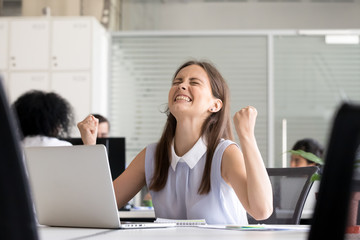 Excited young girl celebrating success business achievement result, looking up, clenching fists good email news, promotion at work, female student happy about great offer or opportunity, passed exam