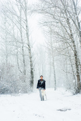 Fototapeta na wymiar Winter walk in a snowstorm with a dog