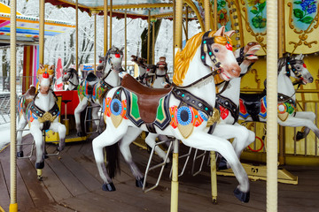 Fototapeta na wymiar Carousel with rocking horses in the park. Children's carousel is closed for the winter season. horses.