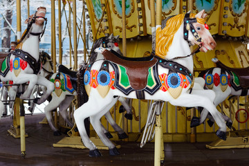 Fototapeta na wymiar Carousel with rocking horses in the park. Children's carousel is closed for the winter season. horses