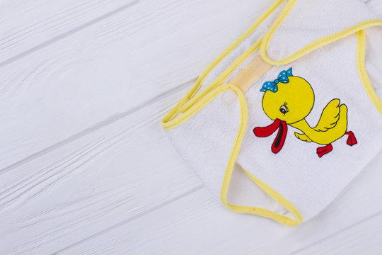 Baby soft underpants with cartoon duck image on wood.