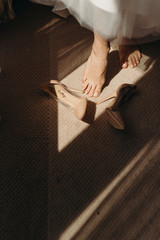 Bride wearing wedding shoes. Art lighting and wedding day
