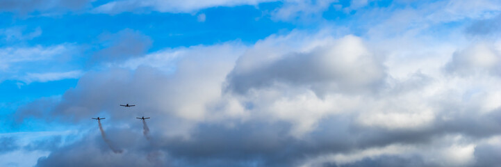 Fototapeta na wymiar Three planes flying at a plane show at a cloudy sky