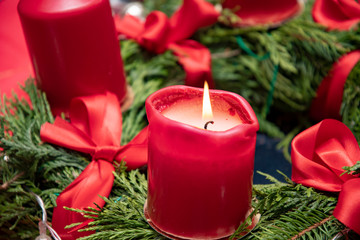 red burning candle on an advent wreath with green twigs