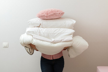 Woman holding a pile of bedding for sleeping