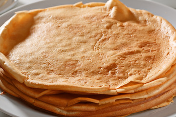 Close-up. A stack of pancakes lies on a white plate