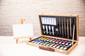 Suitcase with watercolors and mini canvas beside