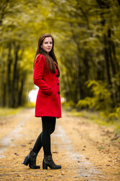Girl in red coat inside the autumn forest