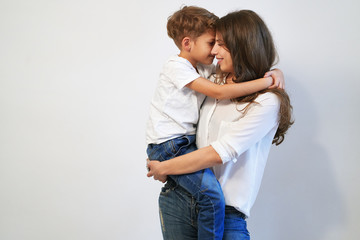 Mother holding her preteen son smiling and looking into his eyes