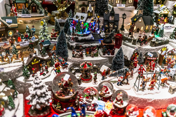 Weihnachtliche Schaufensterdekoartion mit Schneekugeln, Tannenbäumen, Weihnachtsmännern und Weihnachtsgeschichte