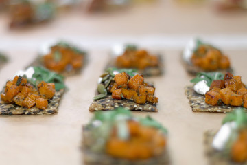 Various finger sandwiches assembled on a parchment paper. Selective focus.