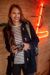 Naklejka premium Happy young hipster woman holds retro photo camera