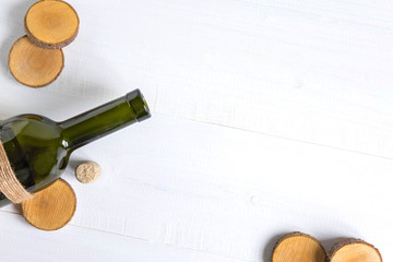 Frame for banner with a bottle of wine. Bottle with wine on a white wooden background. Festive background with place for copy space. Flat lay, top view.