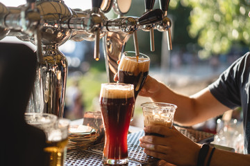 bartender pours a dark beer close up