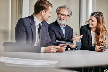 A couple of bussinessmen and bussines woman discussing an important topic