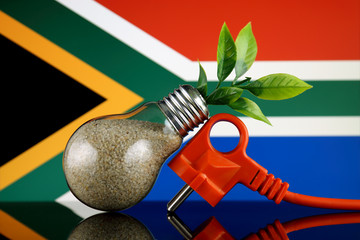 Plug, plant growing inside the light bulb and South Africa Flag. Green eco renewable energy concept.