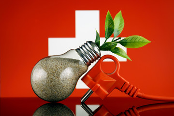 Plug, plant growing inside the light bulb and Switzerland Flag. Green eco renewable energy concept.