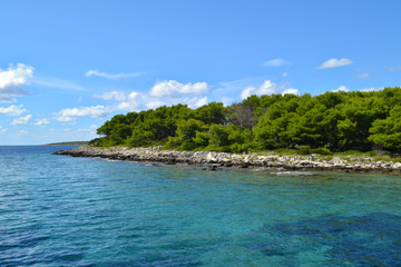 A green rocky island in the azure sea. Blue sky. Croatia.