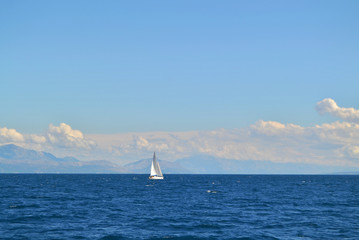 Fototapeta premium Sailing yacht and the sea. Land outline in the distance. Blue sky. Croatia.