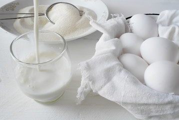Fototapeta na wymiar chicken eggs, milk and flour on a white background