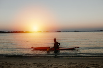 Naklejka na ściany i meble Kajakfahrer bei Sonnenuntergang auf dem Meer