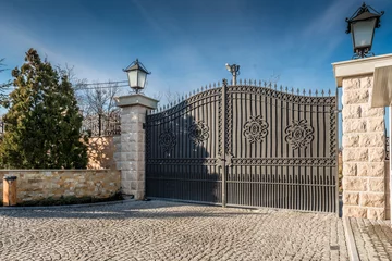 Fotobehang Metal driveway security entrance gates set in brick fence © poplasen