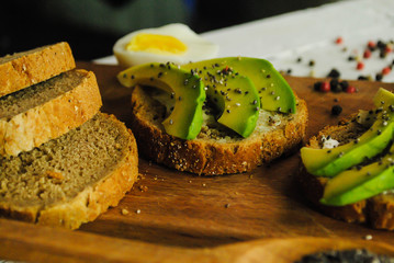 Toast with avocado on a wooden plate and white background
