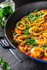 The concept of Spanish cuisine. Paella with seafood, shrimps, squid and greens, cooked in a wok pan on the street. street food.