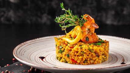 The concept of Spanish cuisine. Paella with seafood, shrimps, squid and greens. Beautiful serving...