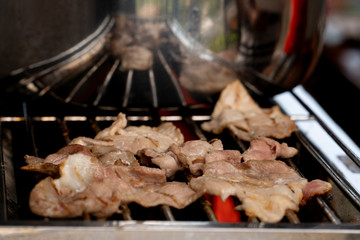 Celebration party roast sliced pork put on hot grill grate. Use heat from the gas.