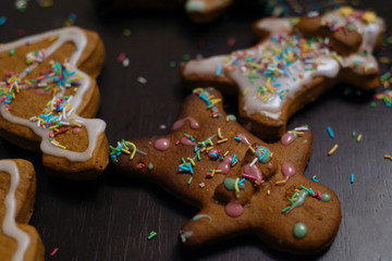 Christmas bakery. Friends decorating freshly baked gingerbread cookies with icing and confectionery mastic, view from above. Festive food, family culinary, Christmas and New Year traditions concept