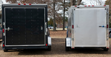 Black and silver transport trailers. Rear view.