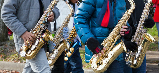 Student musicians with saxophones in fall winter parade.
