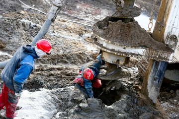 workers at the site in the mud