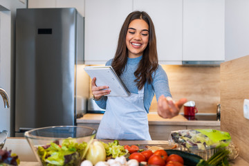 Young brown hair woman reading cookbook in the kitchen