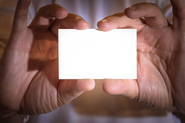 Two hands holding a blank business card.