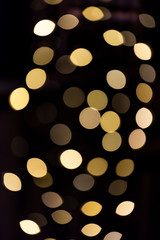 Christmas xmas round bokeh abstract background with yellow golden circles illuminated decoration lights on tree at night evening dark black