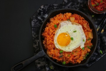 Homemade Kimchi Fried rice topped with fried egg on skillet, overhead view