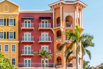 Fotobehang Florida condo, condominium colorful, red and orange multicolored buildings facade exterior with windows, palm trees, real estate property in Spain © Kristina Blokhin