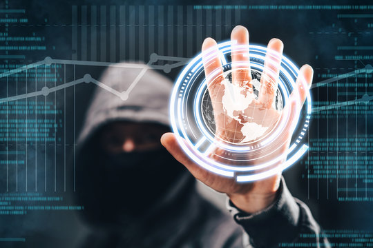 Cyber crime. Male hacker accessing to personal information. Hooded man with obscured face touching digital panel with mixed media and binary code. Virtual crime, cybersecurity concept.