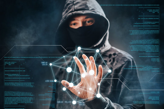 Cyber crime. Male hacker accessing to personal information. Hooded man with obscured face touching digital panel with mixed media and binary code. Virtual crime, cybersecurity concept.